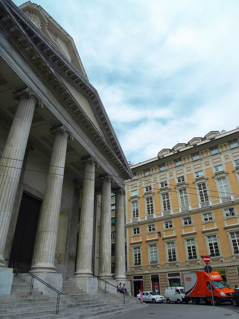 Columns of the theater portico, a modern red sculpture at the foot of the steps