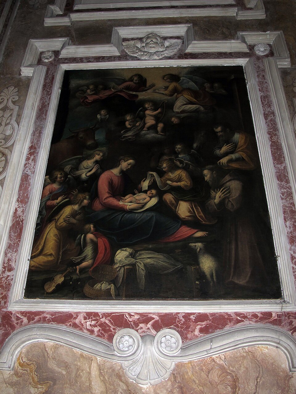 A nativity painting set into the gilded frame of a side altar