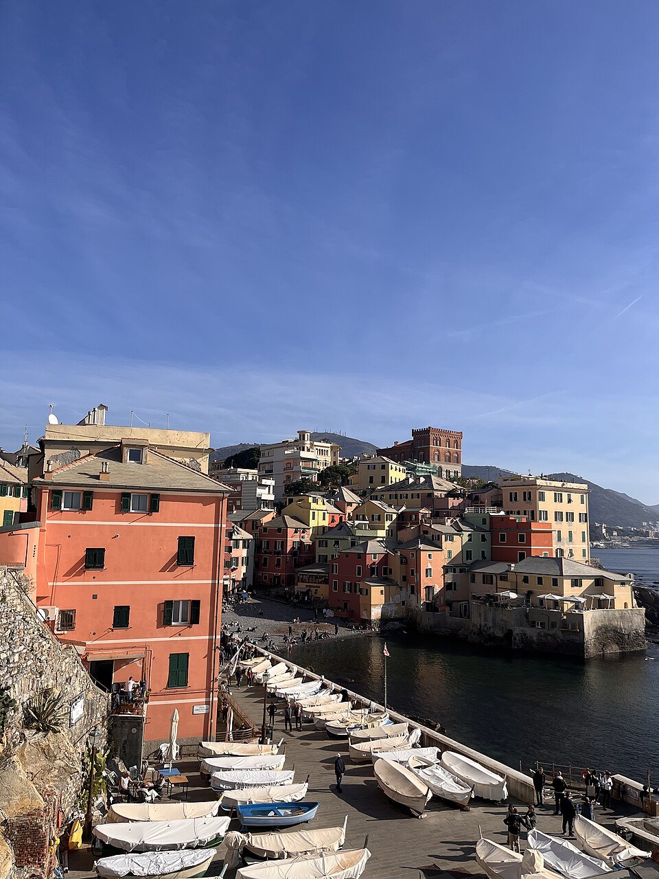 Boccadasse's painted houses above the pebbles, boats drawn up at the water