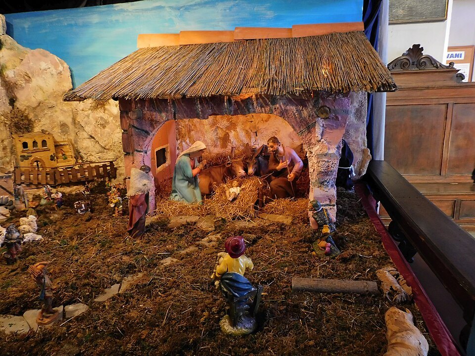 The same nativity from the side, its huts built of bark and stone
