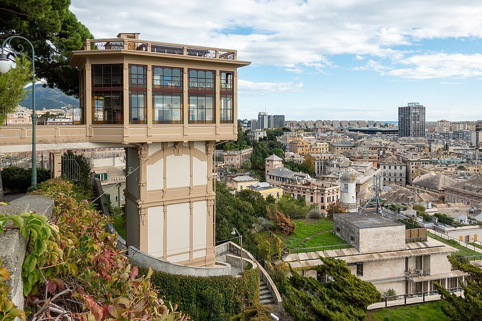 A glazed public lift cabin on its tower, the city falling away below