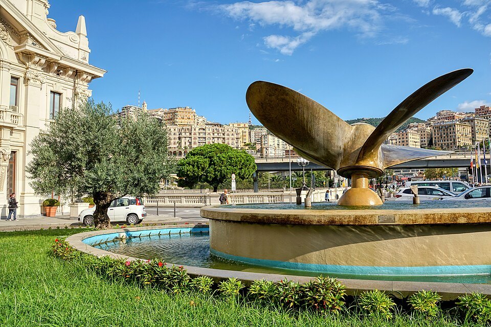 A ship's propeller turned into a fountain outside the Stazione Marittima, the city climbing the hill behind