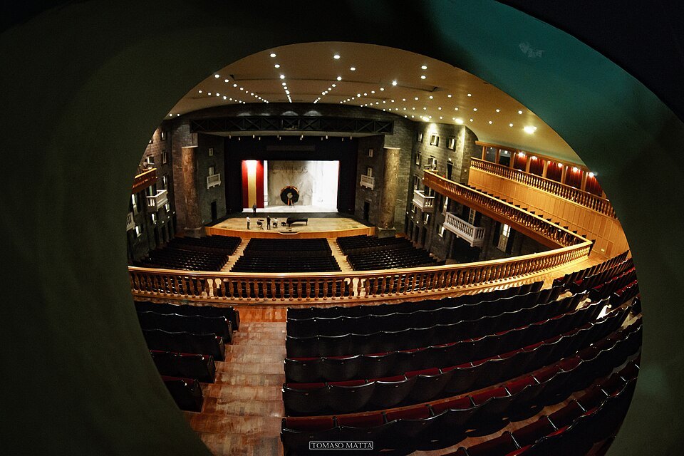 The Carlo Felice lit for a performance, the stage open beyond the stalls