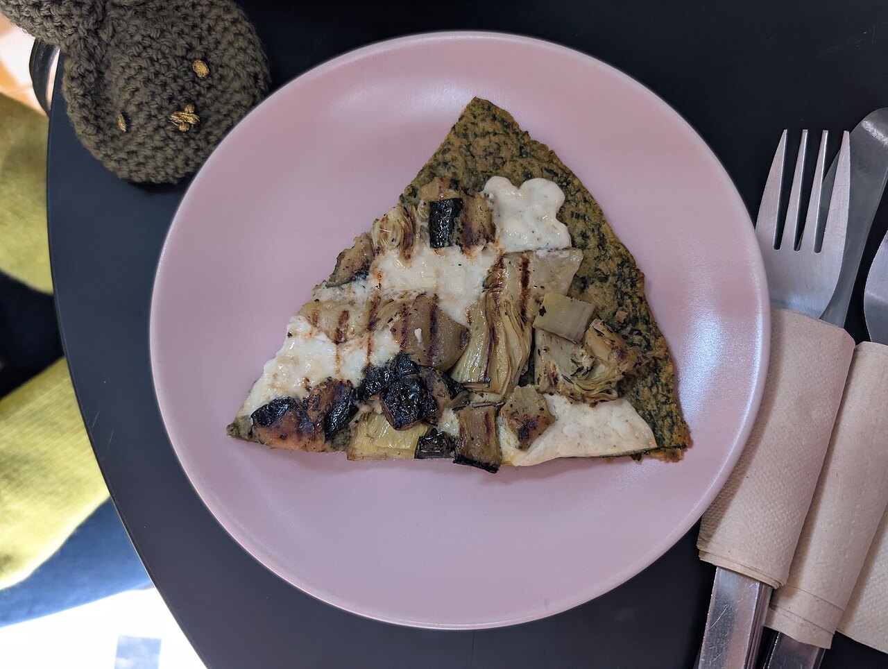 A wedge of farinata on a plate, the chickpea batter baked until it blisters