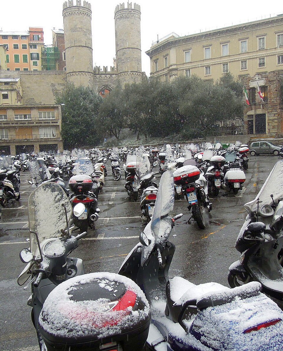 Scooters under snow in front of Porta Soprana