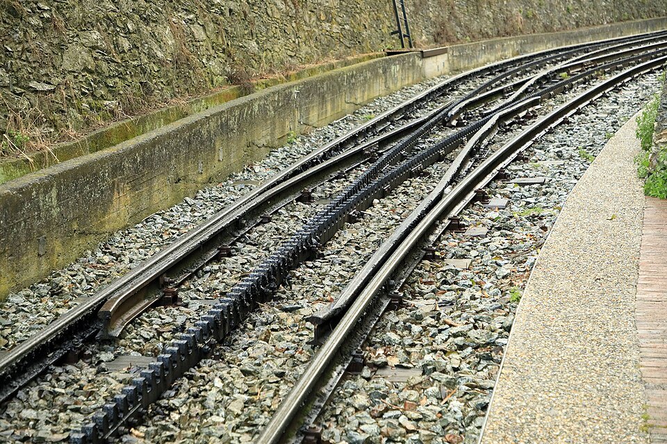 The rack railway's toothed track climbing between retaining walls