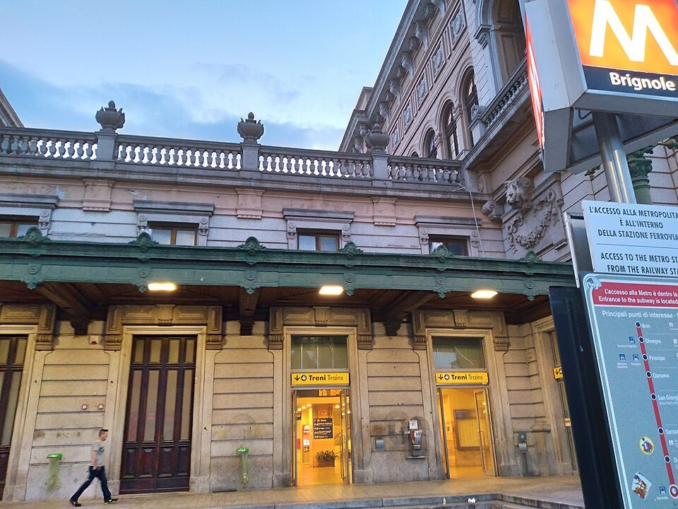 The metro entrance beside Brignole station, its stair dropping under the M sign