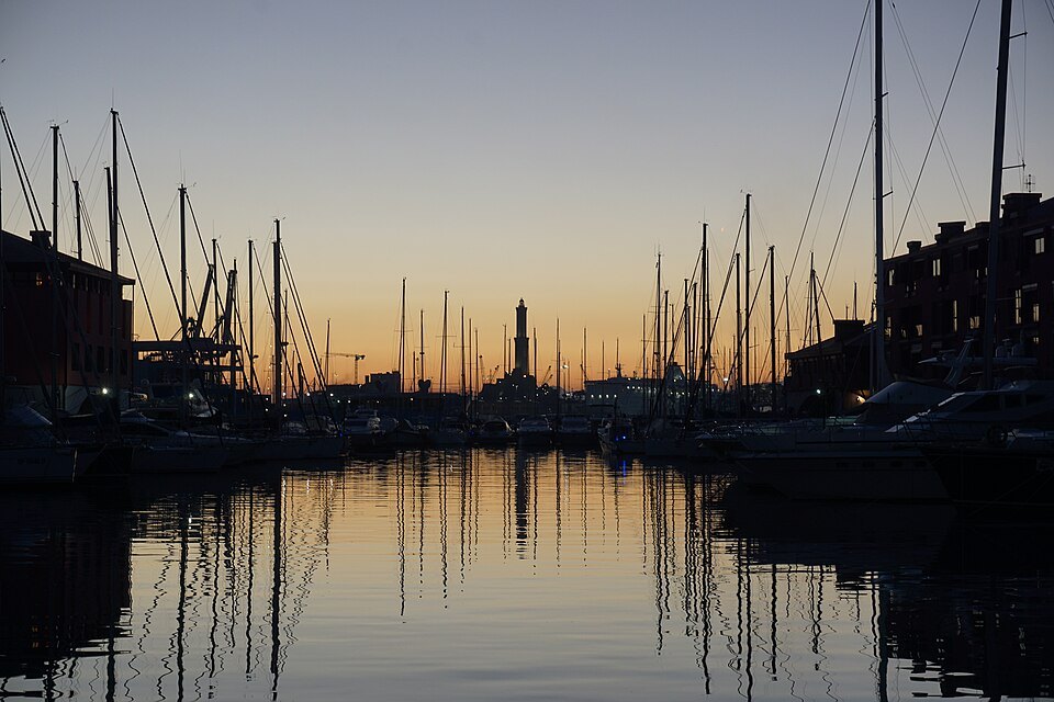 Masts in the old port at dusk, the Lanterna standing beyond them