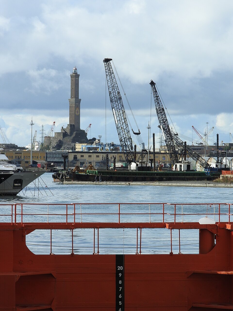 A crane barge and the harbour works below the Lanterna