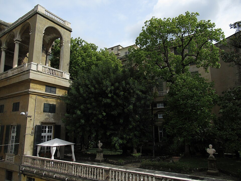 A garden loggia behind a palace, busts set among the trees