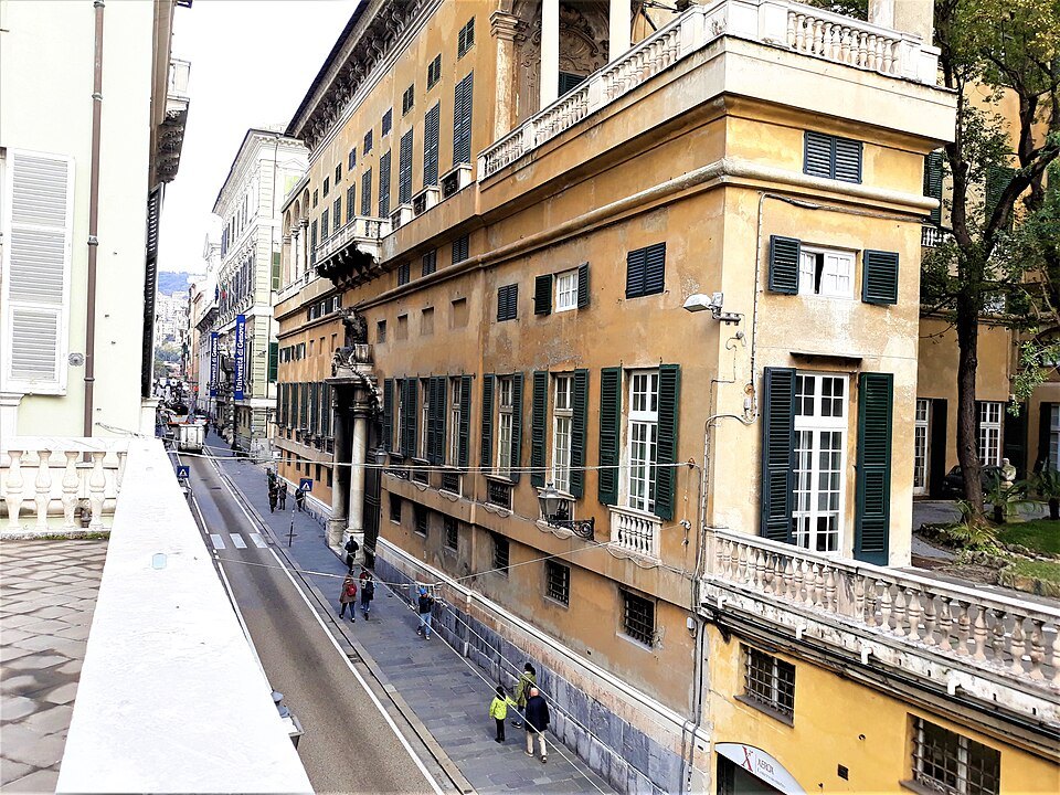 A long palace street from an upper window, walkers small between the fronts