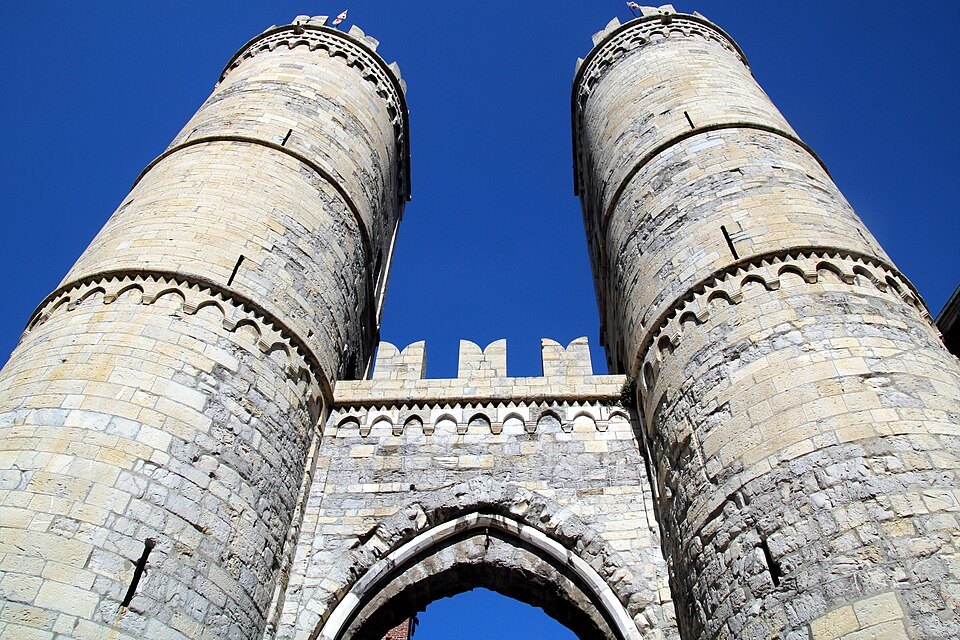 The twin towers of Porta Soprana over their pointed arch, seen from below