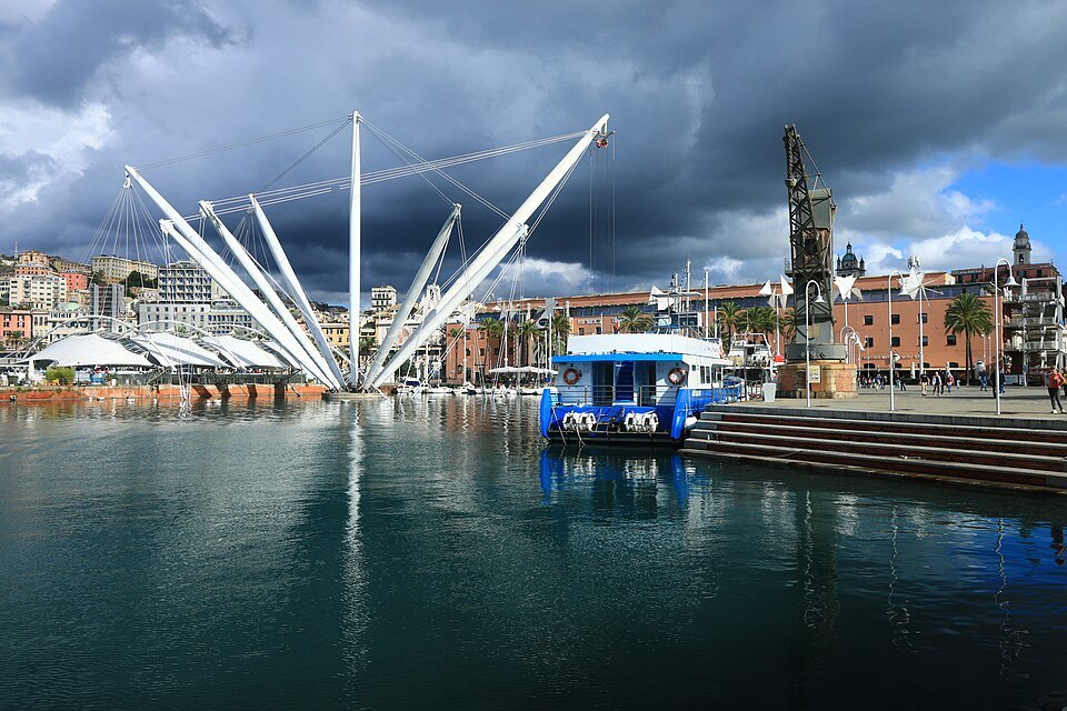 The white arms of the Bigo over the water of the old port under a storm sky
