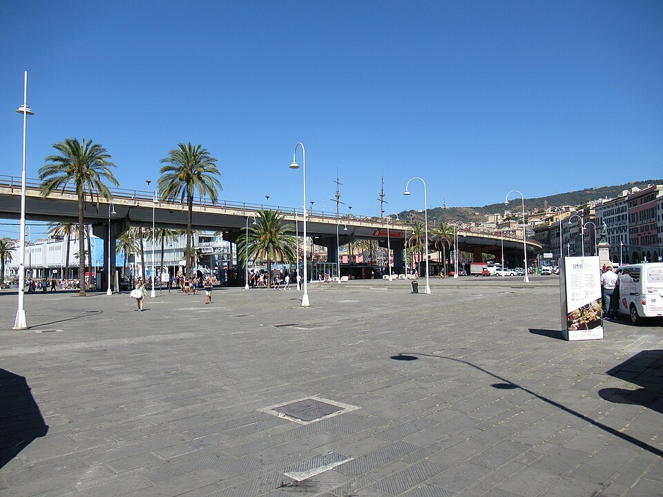 The wide paved space of Piazza Caricamento under the elevated road