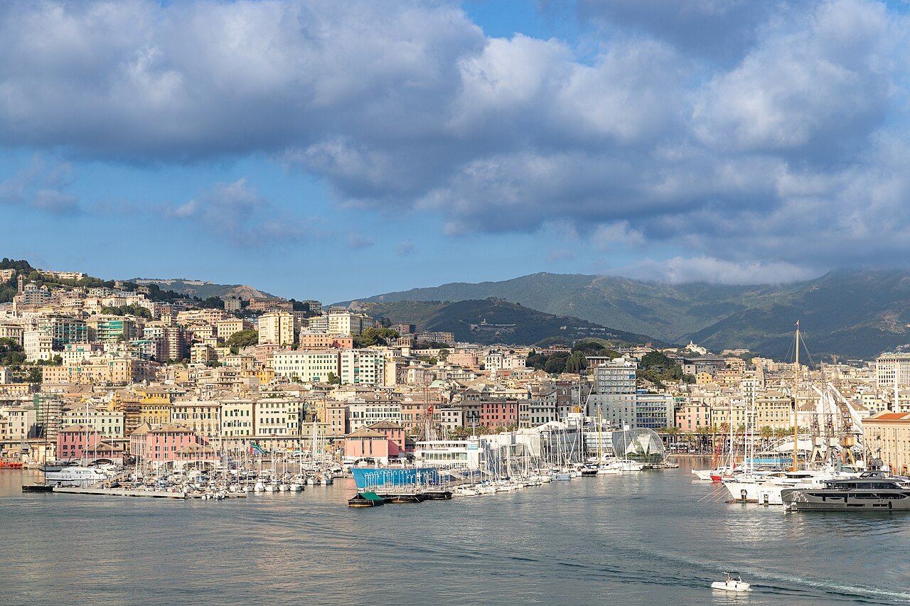The city stacked along its harbour, seen from the water with the hills behind