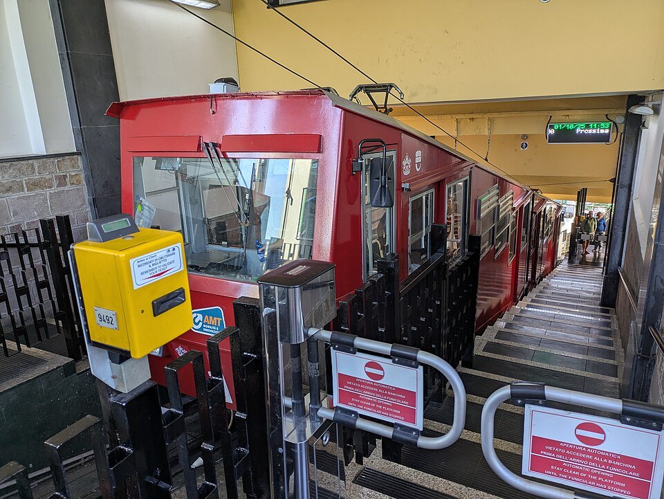 The funicular cabin at the platform, ticket machine beside the gate