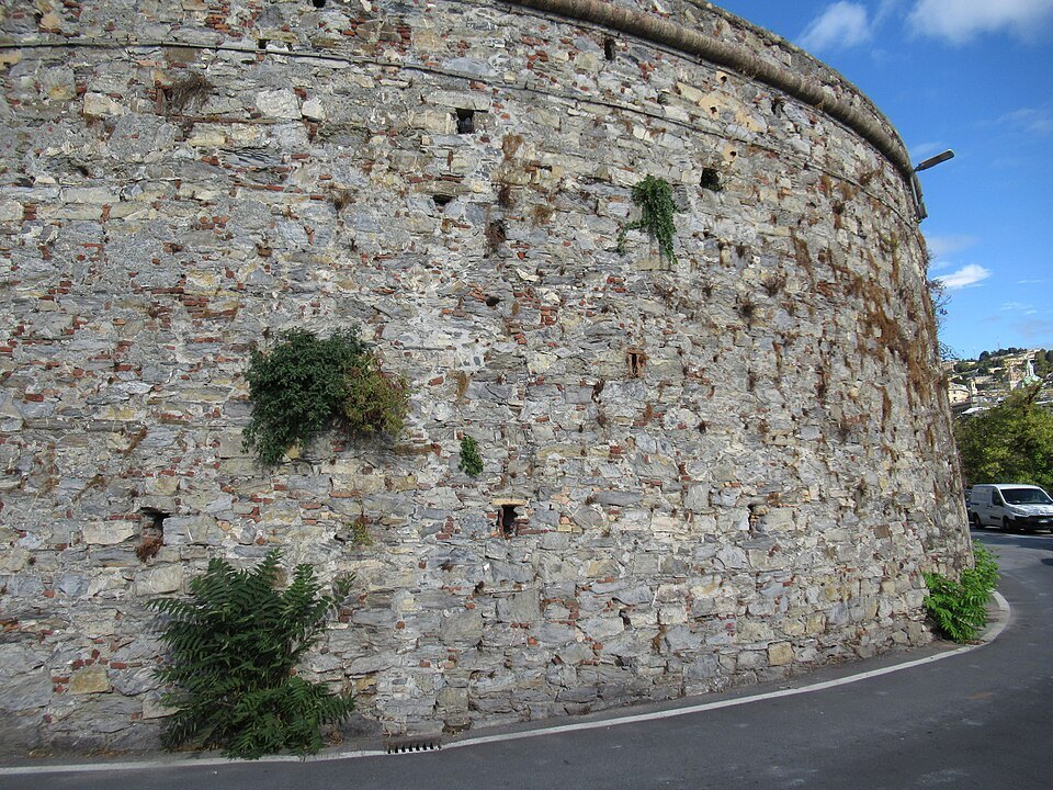 The curved bastion of the Acquasola wall, grass growing out of its stones