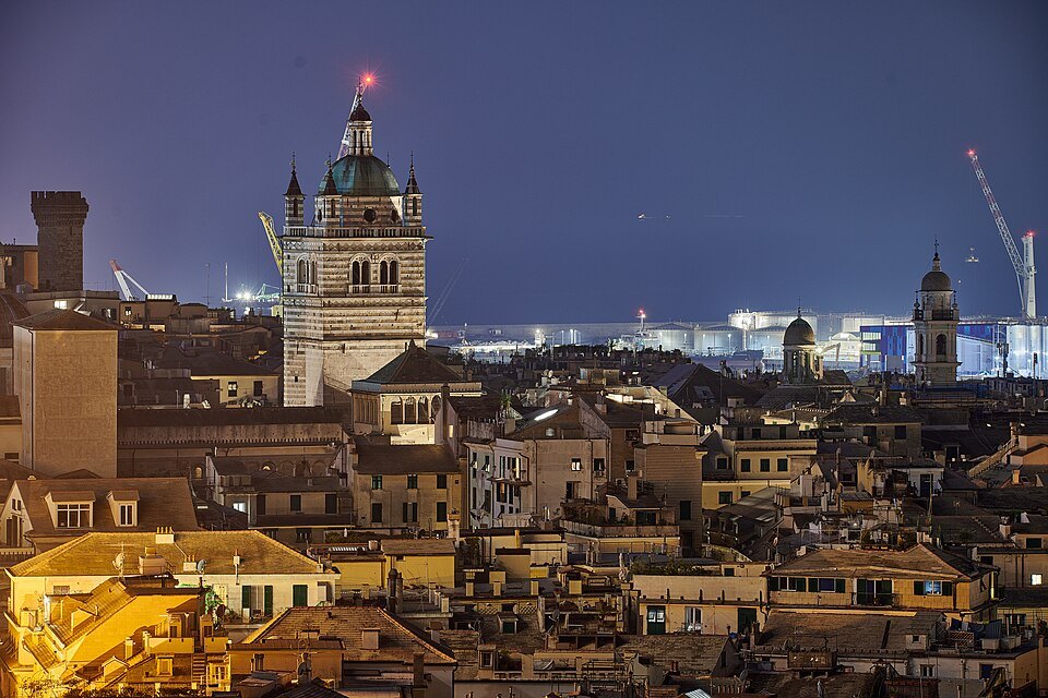 The old town at dusk from above, the cathedral tower lit among the roofs