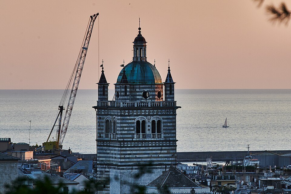 The dome and bell tower of San Lorenzo above the roofs, with the sea behind