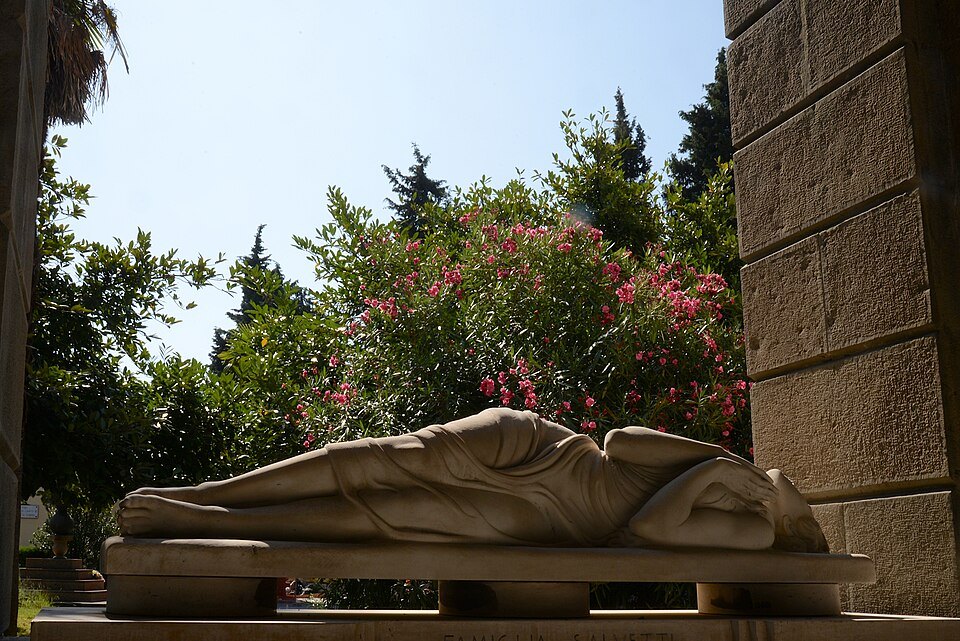 A reclining marble figure on a tomb in the galleries at Staglieno